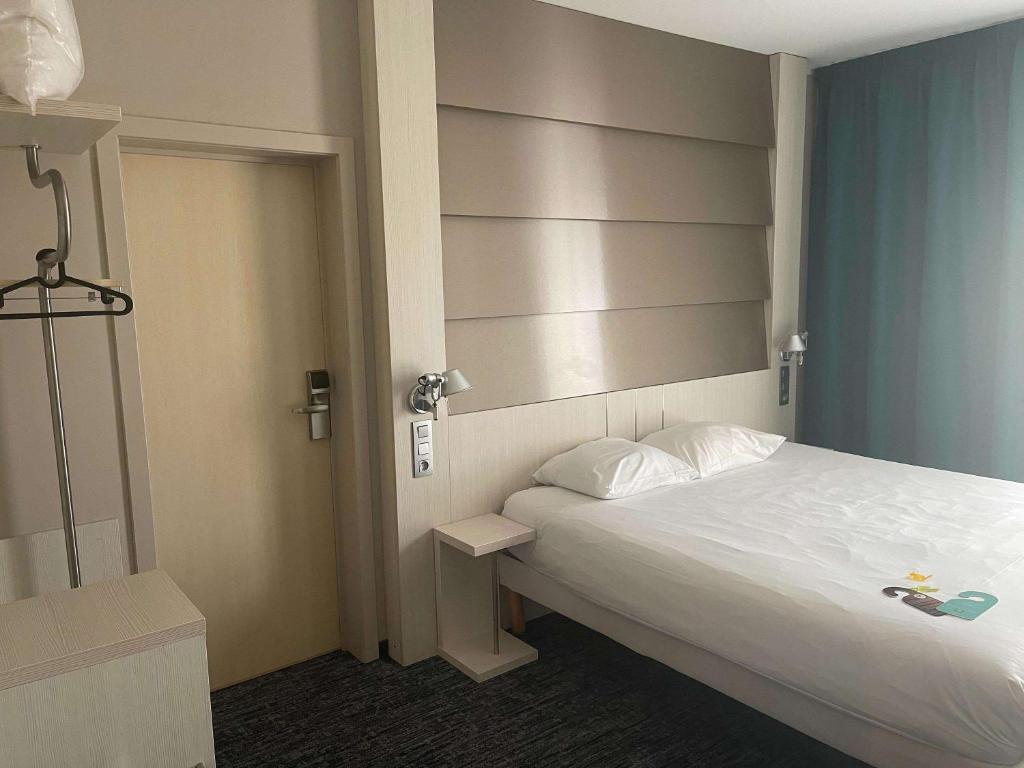 a small bedroom with a bed and a headboard at ibis Styles Nivelles in Nivelles