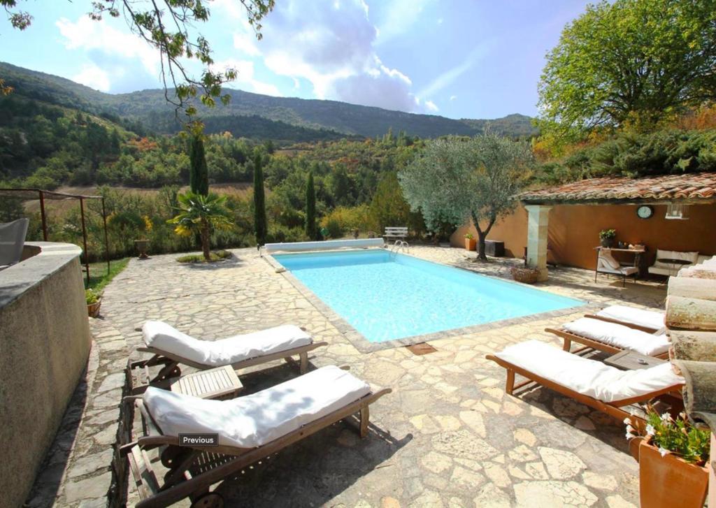 a swimming pool with lounge chairs and a house at Le miau in Vercoiran