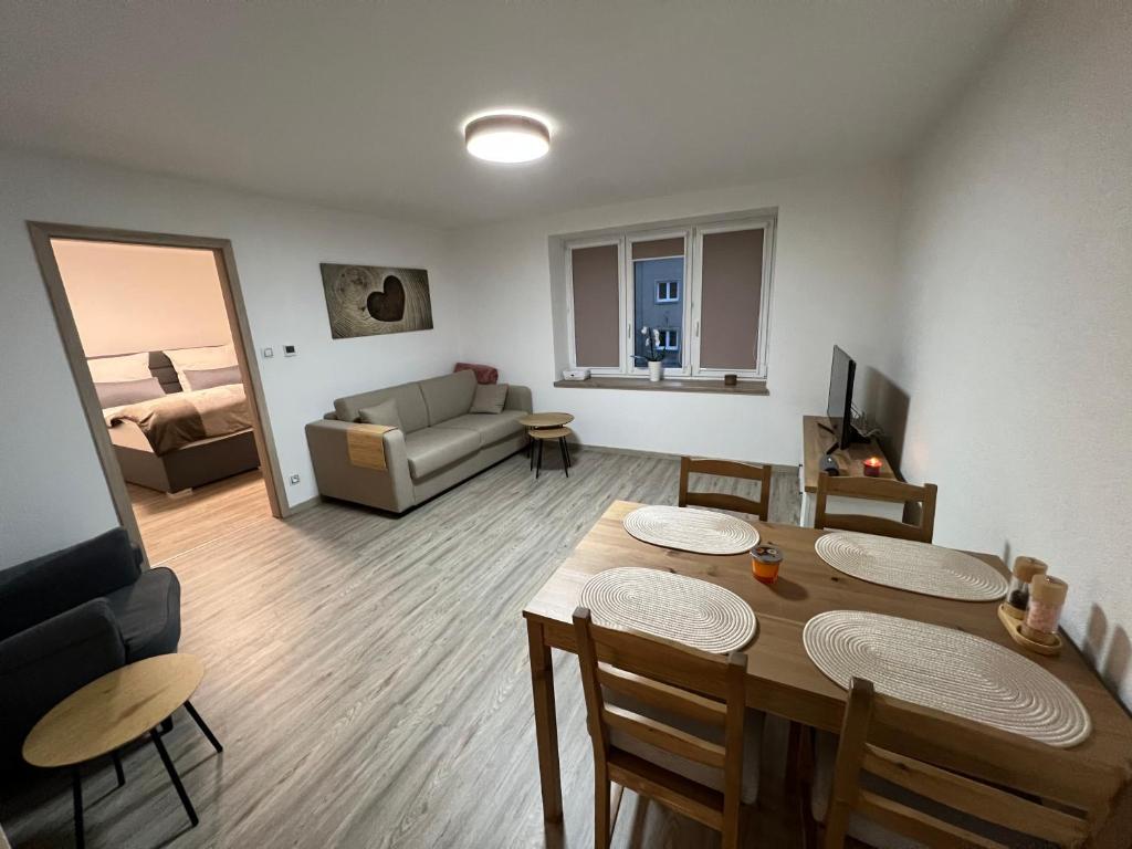 a living room with a dining table and a couch at Apartmán MD in Žacléř