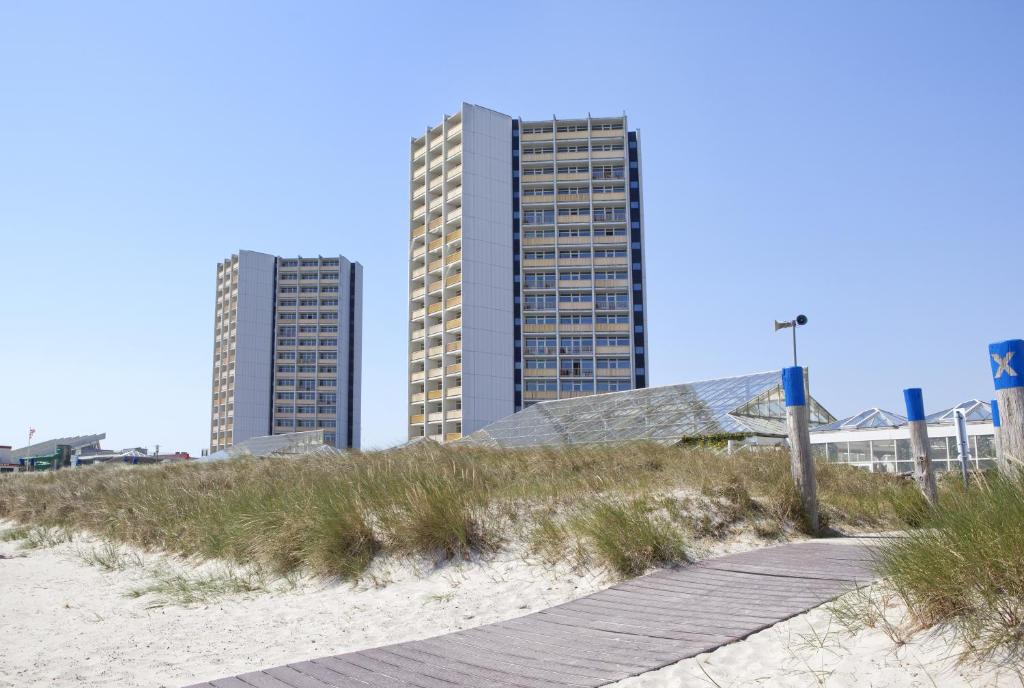 菲曼堡的住宿－費馬恩島IFA假日酒店，海滩上两栋高楼,有木板路
