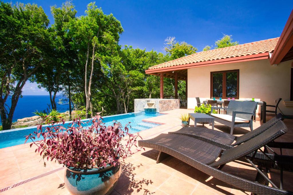 a patio with a swimming pool and a house at Chula Vista Home in West Bay