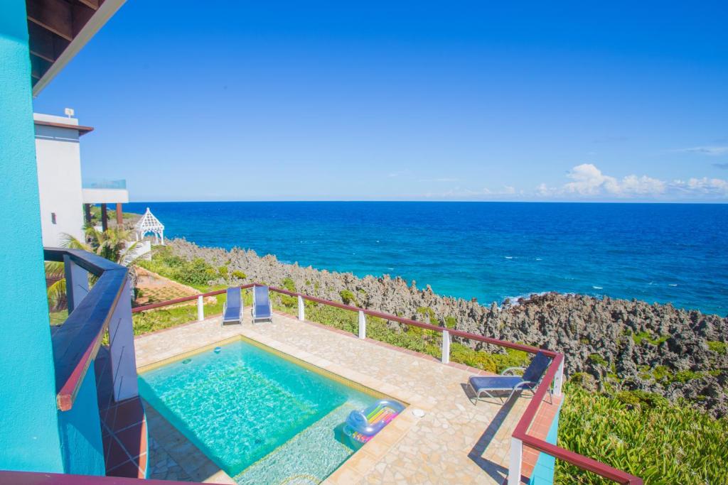 a swimming pool with the ocean in the background at Oceanfront Coral View Home in West Bay