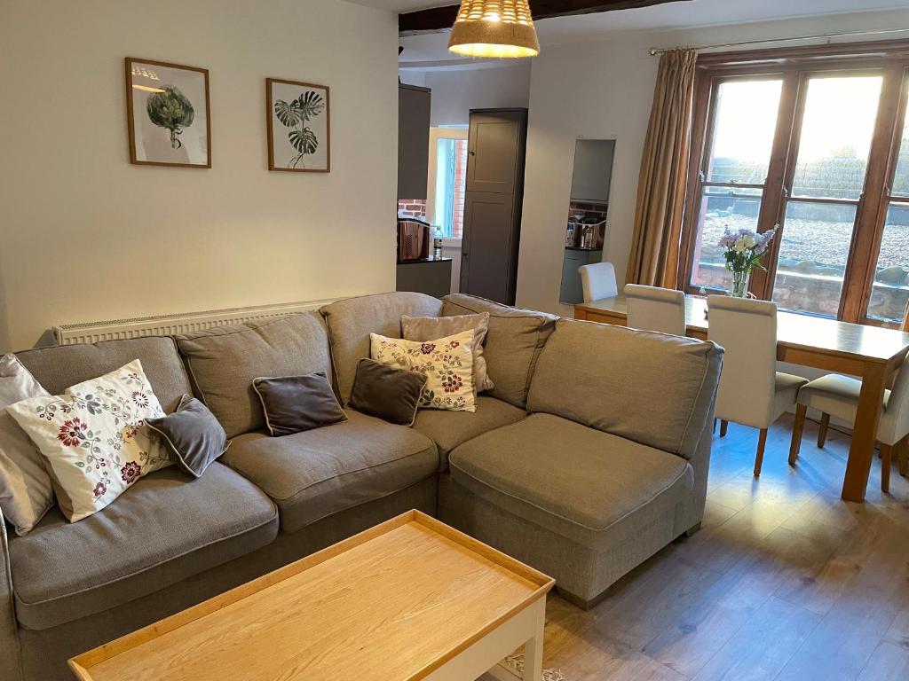 een woonkamer met een bank en een tafel bij One Long Entry with Terrace Bay View in Lyme Regis