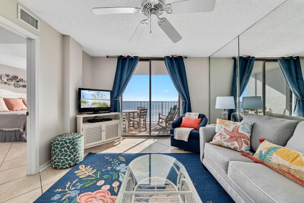 uma sala de estar com um sofá e uma televisão em Sunswept 702 condo em Orange Beach