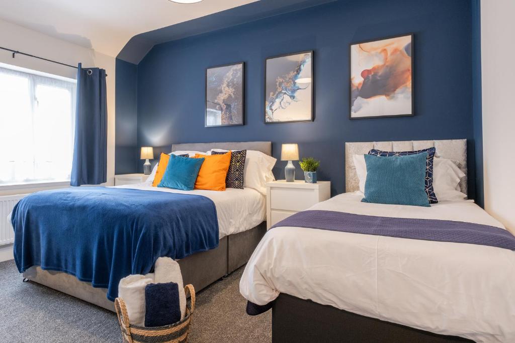 2 camas en una habitación con paredes azules en Hazel House en West Bromwich
