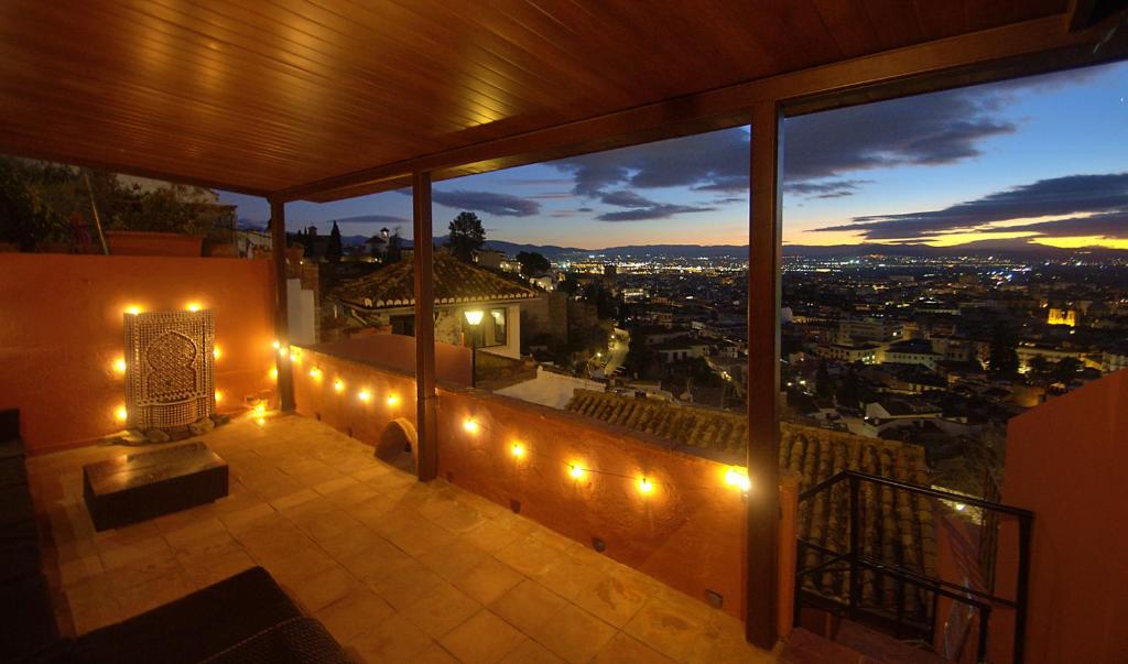a balcony with a view of a city at night at House&Cave Parking and Terrace, in the city in Granada