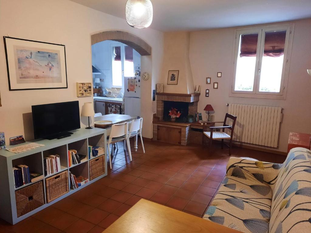 sala de estar con sofá, TV y mesa en Cà Rossa, en Imola