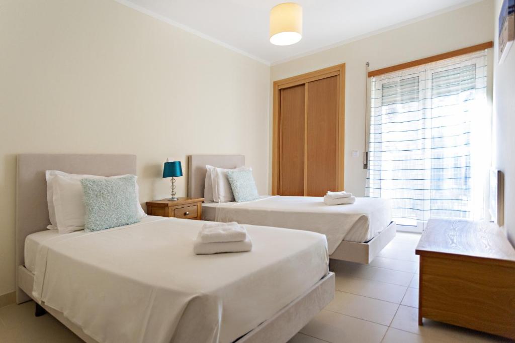 a bedroom with two beds and a window at Ocean Breeze Apartment in Cabanas de Tavira