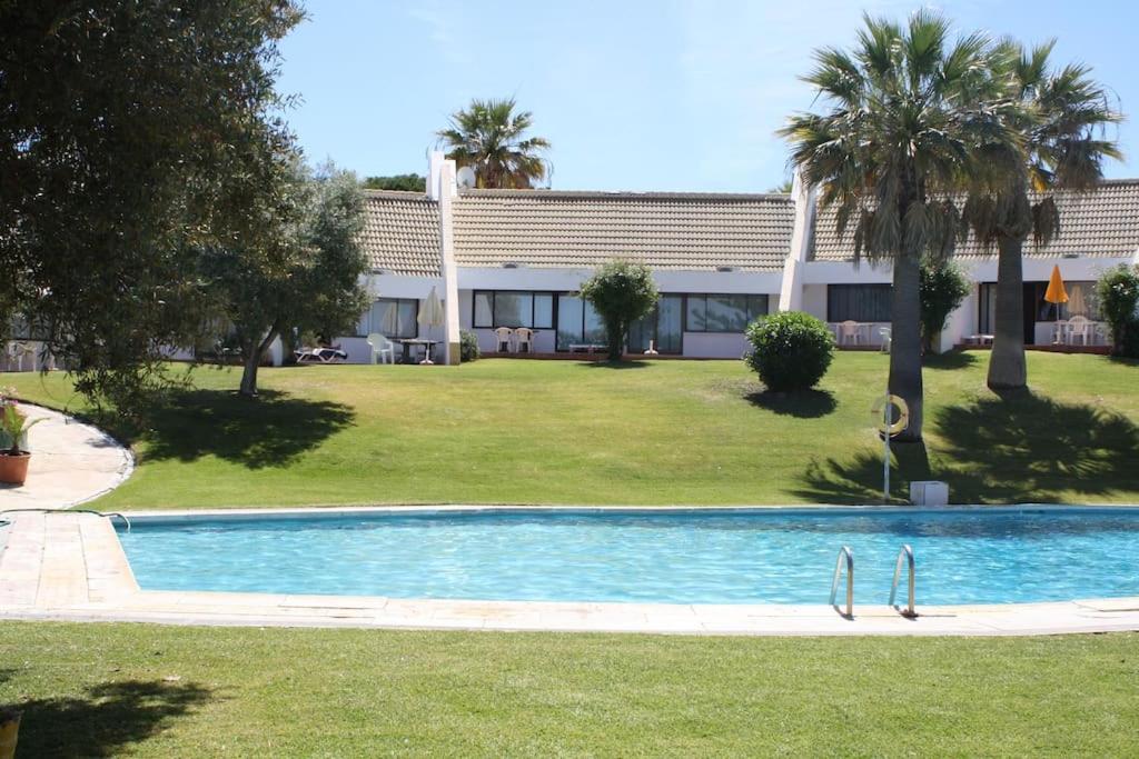 a resort with a swimming pool in front of a building at Mouragolf 3 bedroom townhouse in Vilamoura