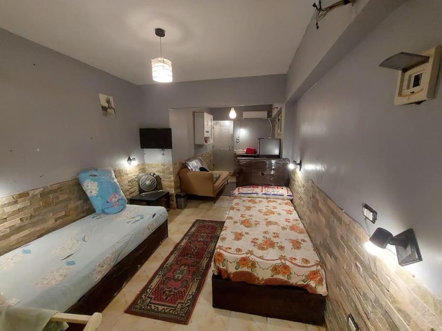 une chambre avec deux lits et un salon dans l'établissement Aatun Studio in makatam mountain, au Caire
