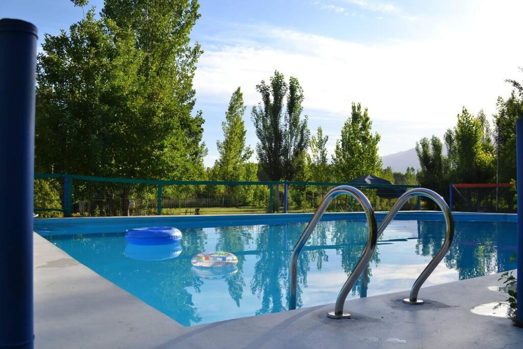 a swimming pool with a blue pool at Cabaña Ascensión-Caminos del Vino in Colonia Las Rosas