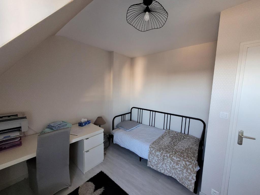 a small bedroom with a bed and a desk at Chez Aurélie in Brest