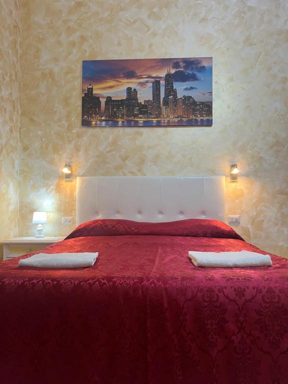 Rose Village Guest House في روما: غرفة نوم بسرير احمر وعليها وسادتين
