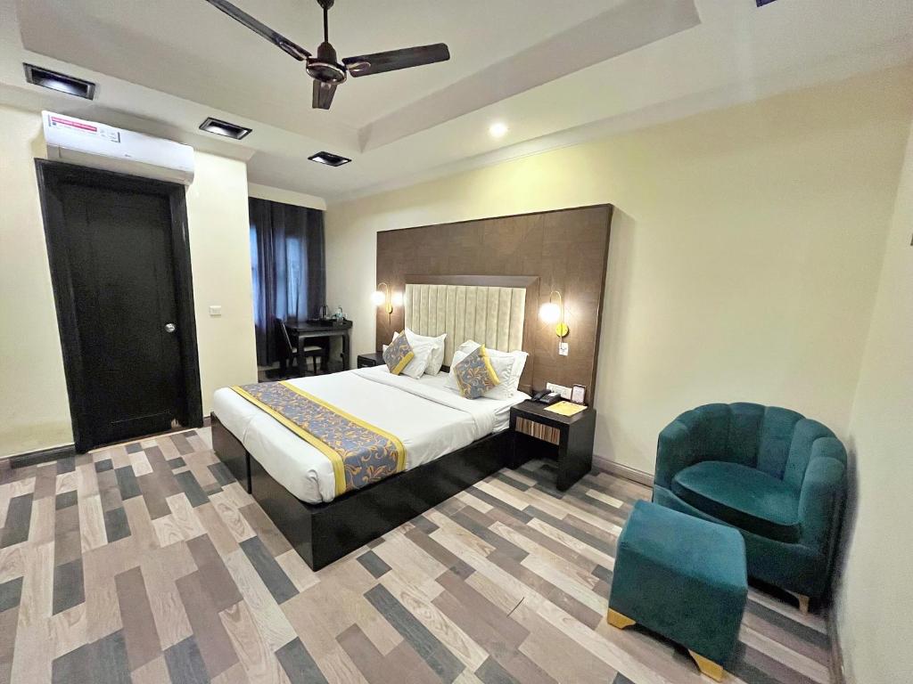 Habitación de hotel con cama y silla en The Oakland Plaza by Orion Hotels en Nueva Delhi