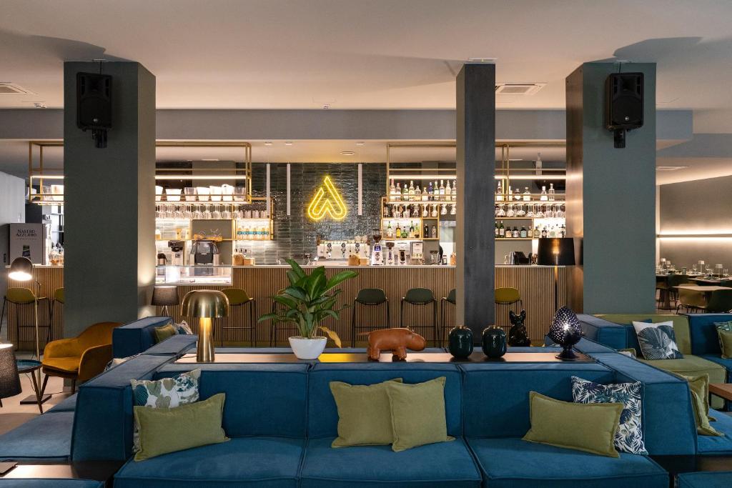 レッチェにあるArryvo Hotelの青いソファとバーのあるロビー