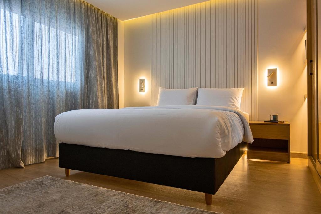 a bedroom with a large bed and a large window at Parkside Boutique Serviced Apartments in Cairo