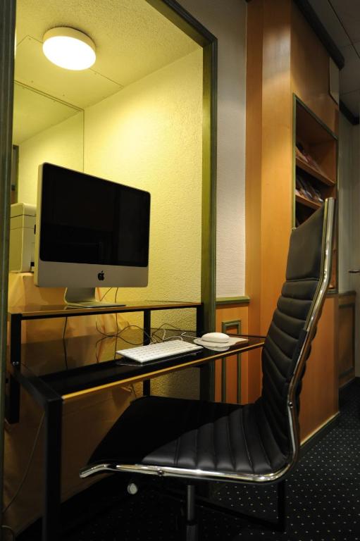 escritorio con monitor de ordenador y silla en Hotel Arlette Beim Hauptbahnhof, en Zúrich
