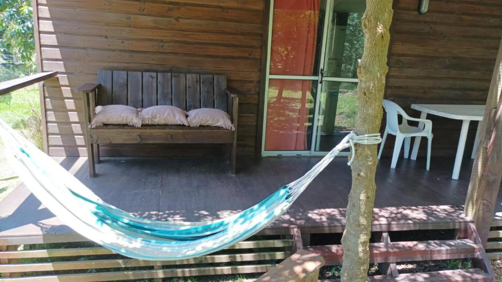 a hammock on the porch of a cabin at • Cabaña Las Hortensias • in La Pedrera