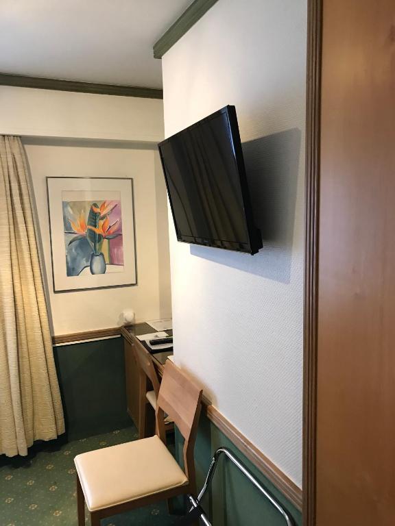 Una televisión o centro de entretenimiento en Hotel Arlette Beim Hauptbahnhof