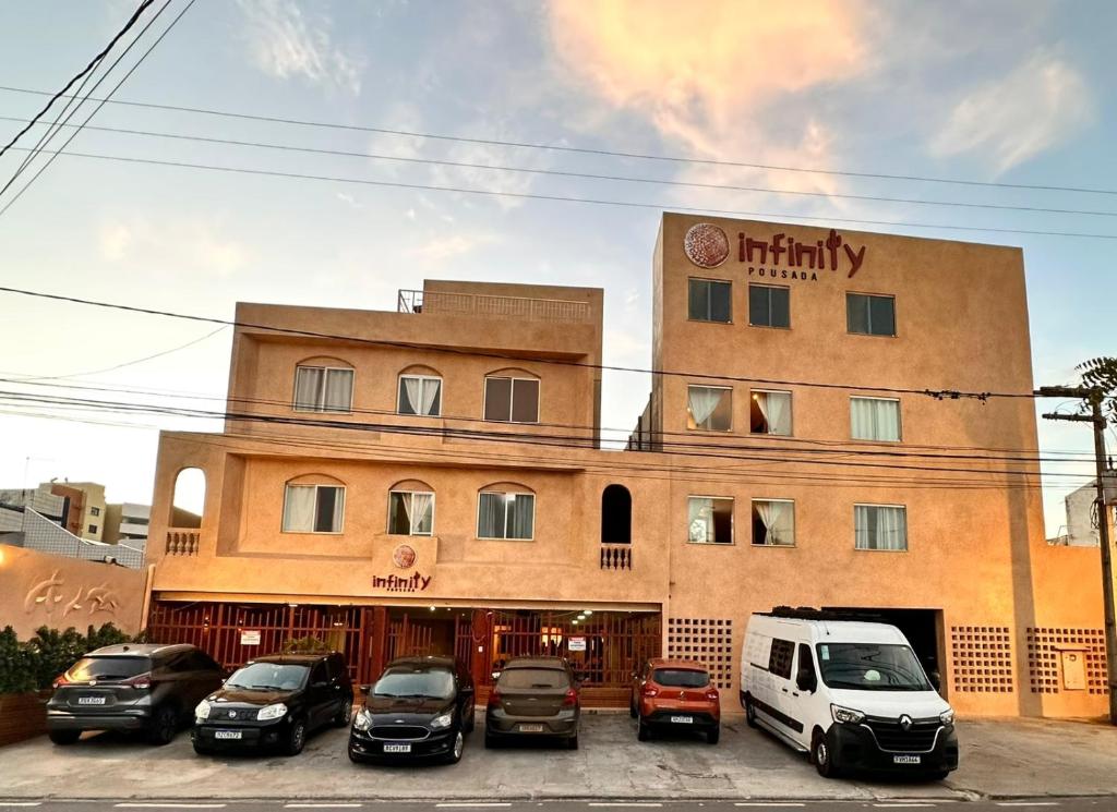 un edificio con coches estacionados frente a él en Infinity Pousada, en Aracaju