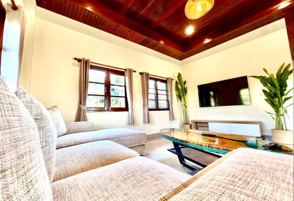 ein Wohnzimmer mit 2 Sofas und einem Couchtisch in der Unterkunft Lake & lotus ponds view 2nd floor Villa in Thongsala