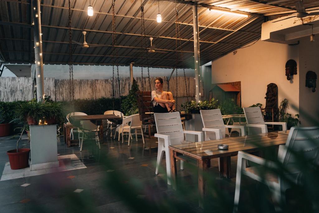 a woman standing in a room with chairs and tables at JHouse near Bhikaji in New Delhi