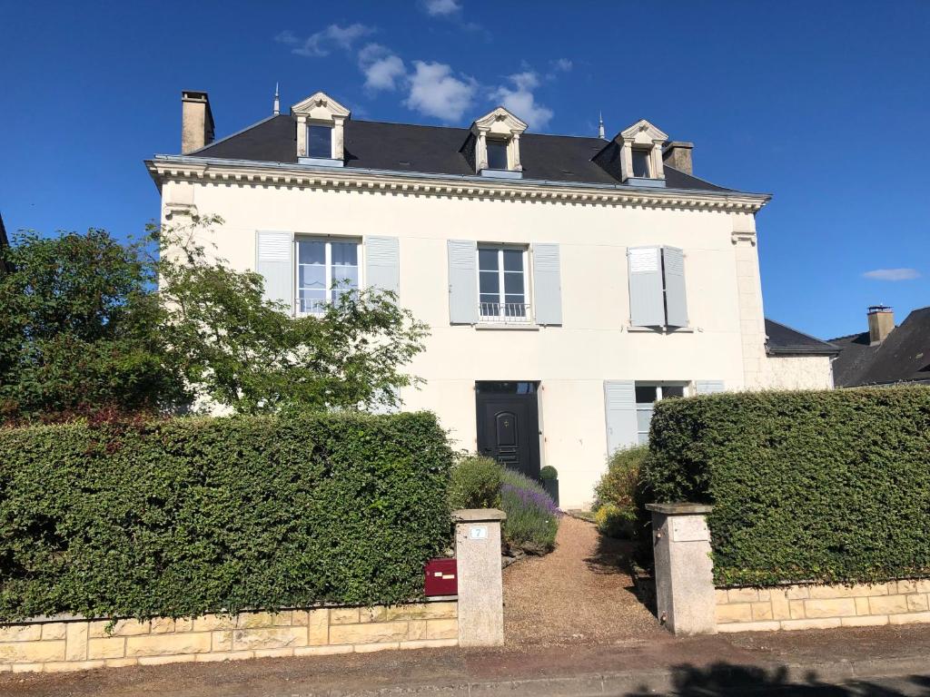 a white house with hedges in front of it at Maison du 7 in Saint-Ouen-en-Belin