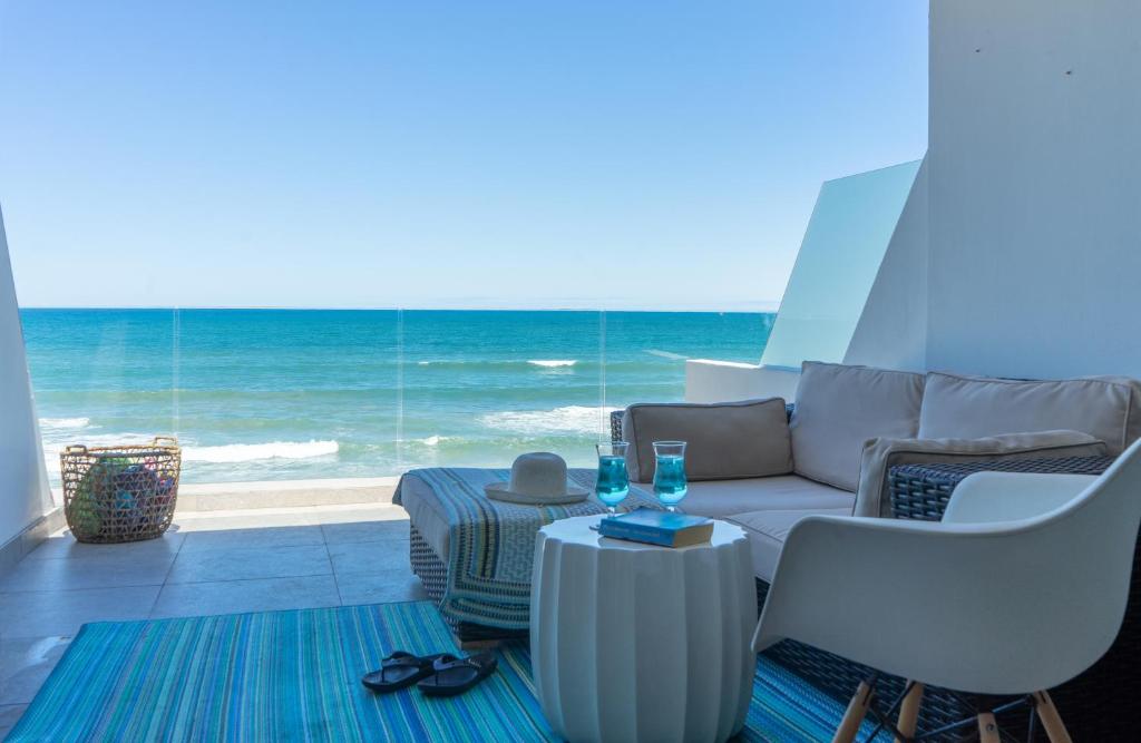 a living room with a couch and a view of the ocean at De Branders Woonstel No 56 & 67 in Hartenbos