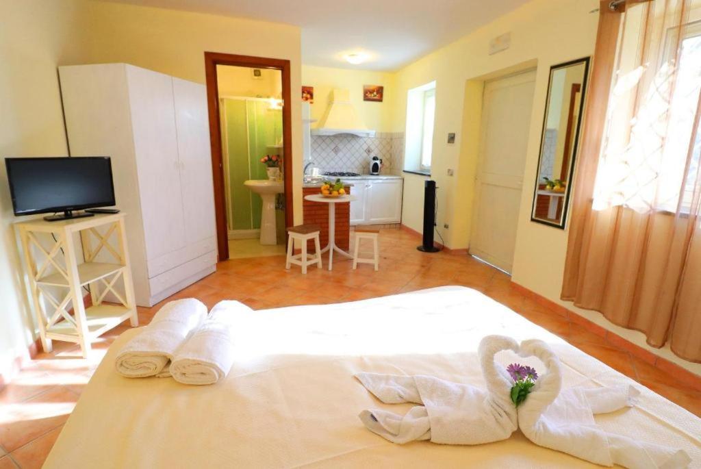une chambre avec un lit et des serviettes et une cuisine dans l'établissement RELAX MARGHERITA, à Colli di Fontanelle