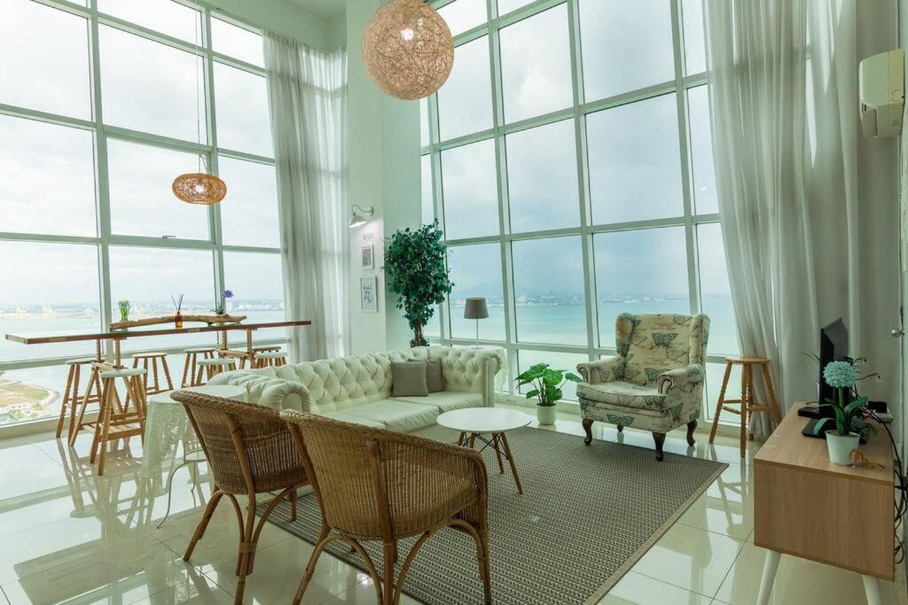 a living room with a couch and chairs and windows at 2bedrooms Maritime Seaview Luxury Suite 2Carpark 2-9pax in Jelutong
