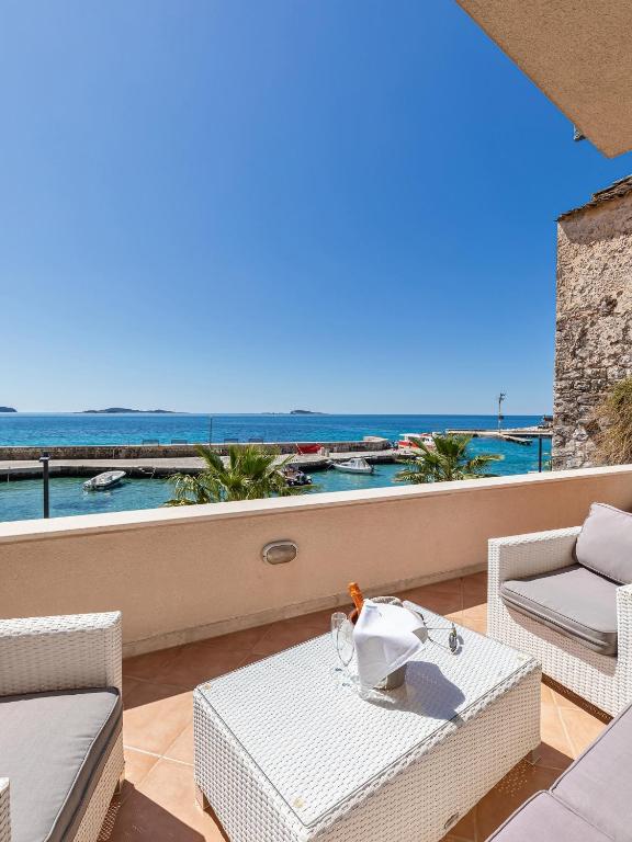 a balcony with a table and chairs and the ocean at Villa Ana Apartments in Mlini