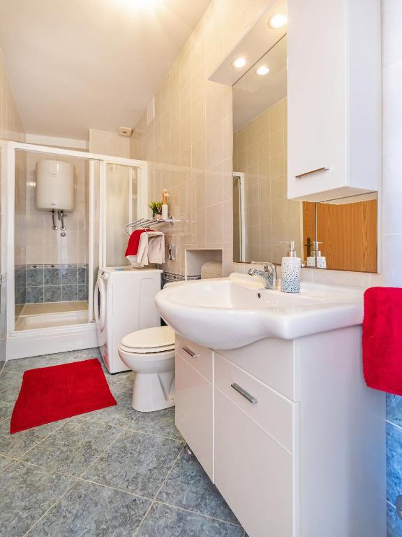 a bathroom with a white sink and a toilet at Villa Ana Apartments in Mlini