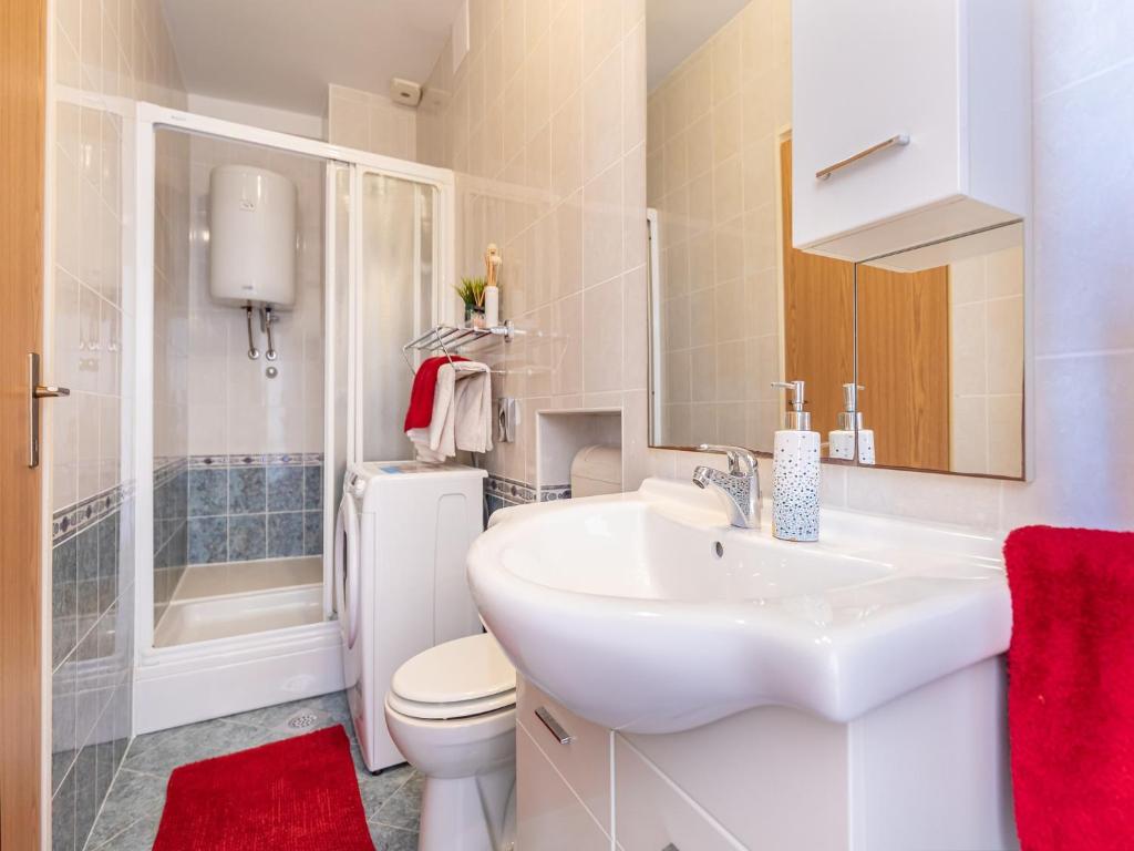 a white bathroom with a sink and a toilet at Villa Ana Apartments in Mlini
