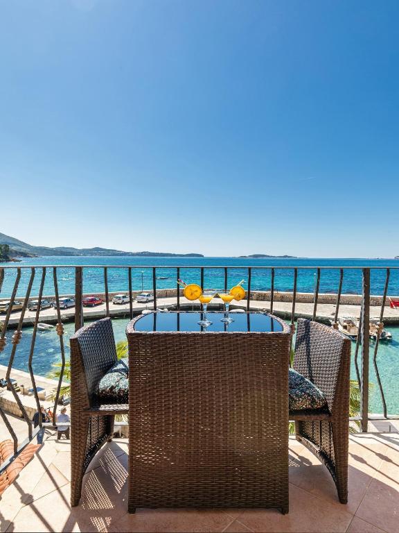 a table and chairs on a balcony overlooking the water at Villa Ana Apartments in Mlini