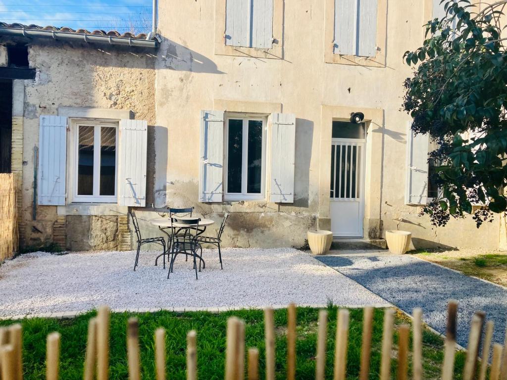 a table and chairs in front of a building at Appartement Riquet - centre ville, rdc, climatisé, jardin, parking privée in Castelnaudary