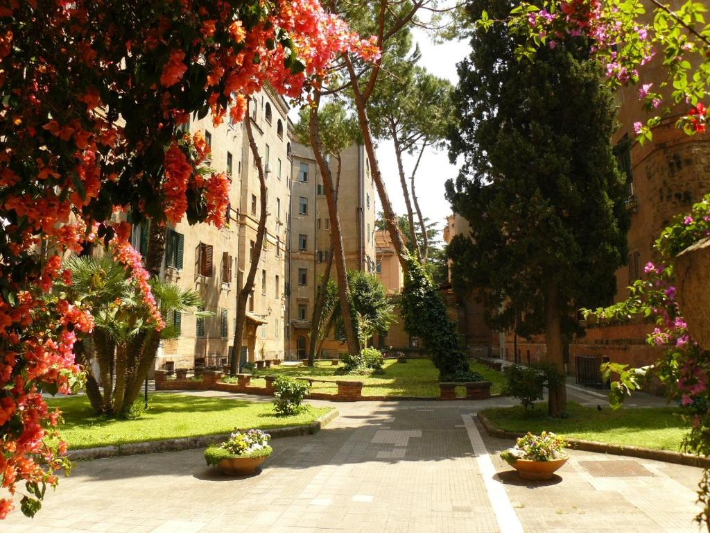 une cour d'un immeuble avec des fleurs et des arbres dans l'établissement Dimora del Papa, à Rome