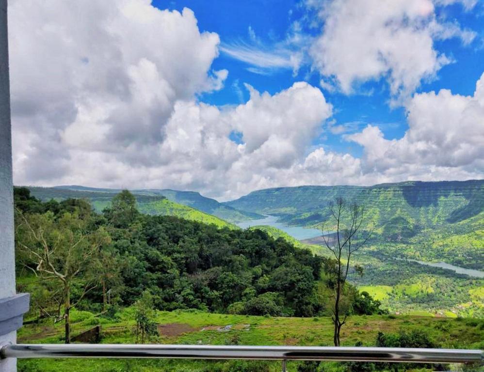 a view of a valley with trees and a blue sky at Harmony Palace in Mahabaleshwar