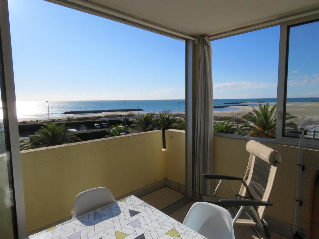 un balcon avec une table et des chaises et une vue sur la plage dans l'établissement T2 à Sète, 30m², Vue Mer, Parking Privé - FR-1-472-134, à Sète