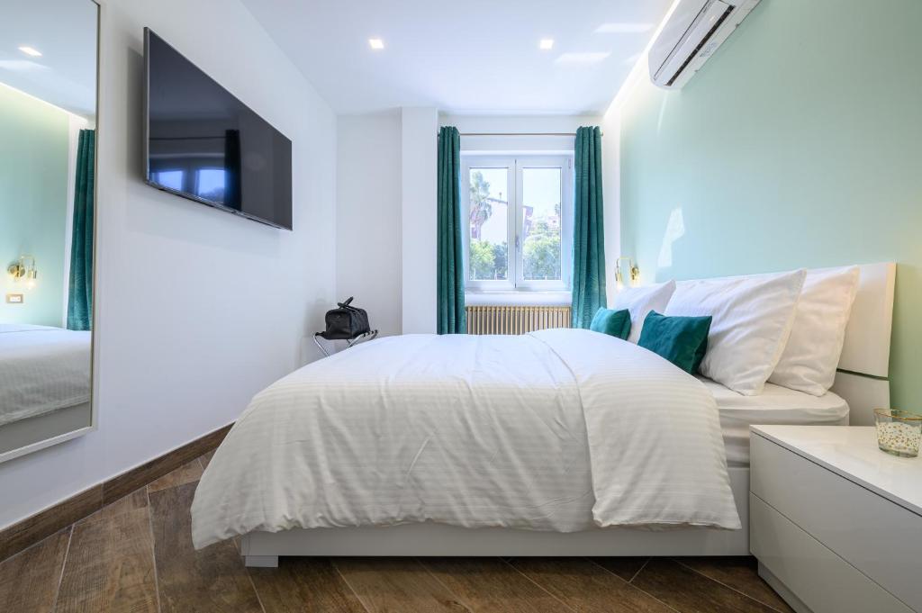 ein weißes Schlafzimmer mit einem Bett und einem Fenster in der Unterkunft Villa In Bed in Neapel