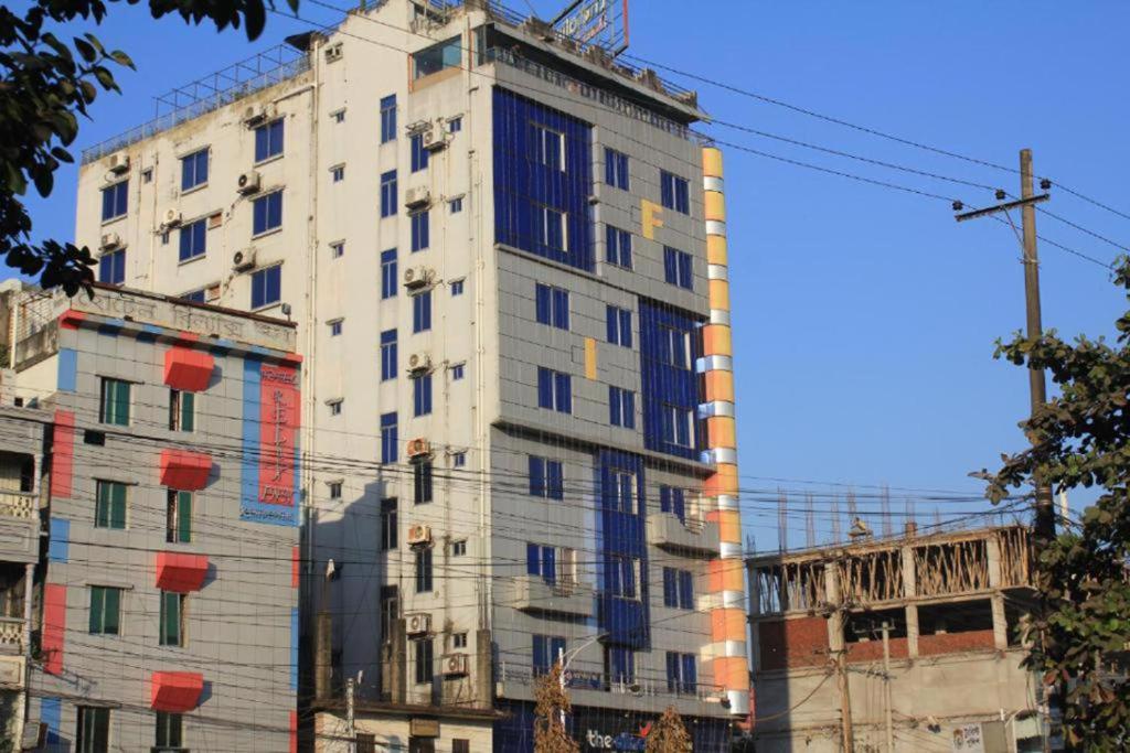 un edificio blanco alto con muchas ventanas en The Alina Hotel & Suites, en Chittagong