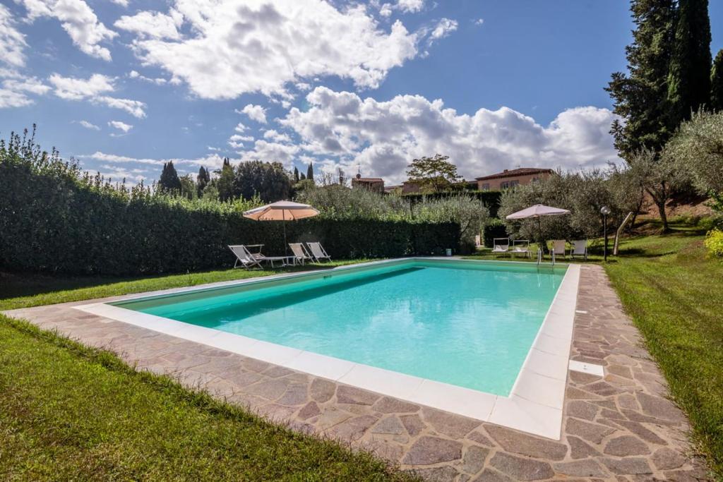 una piscina en un patio con sombrillas en Al Giardino degli Ulivi, en Santa Maria Albiano
