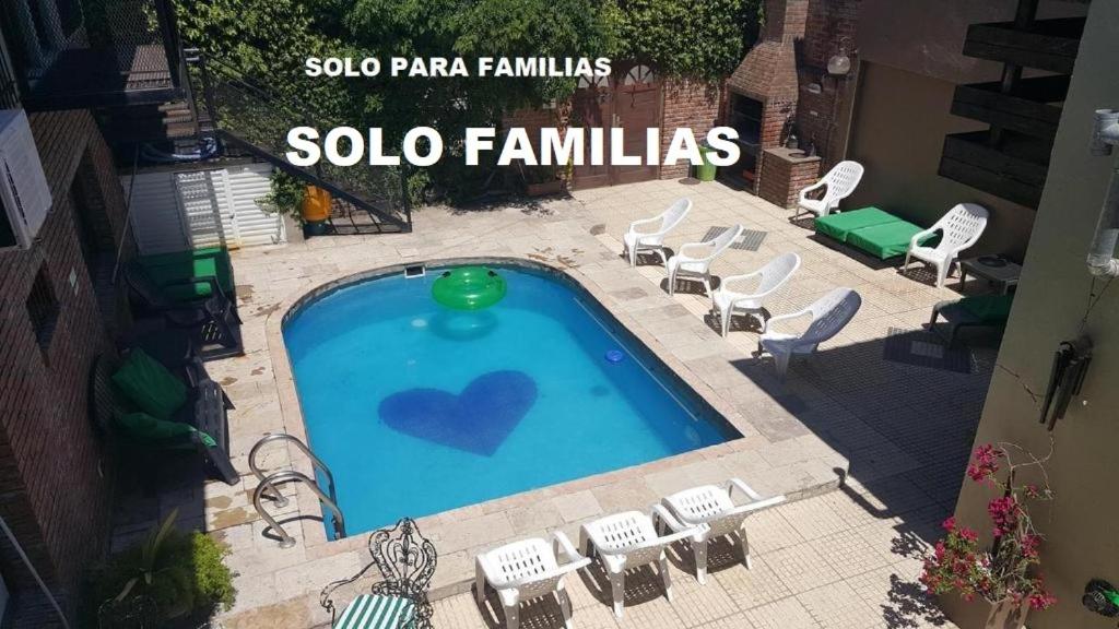 una piscina con sillas y un cartel que diga solo familia en Apartamentos Esquiu en Mar del Plata