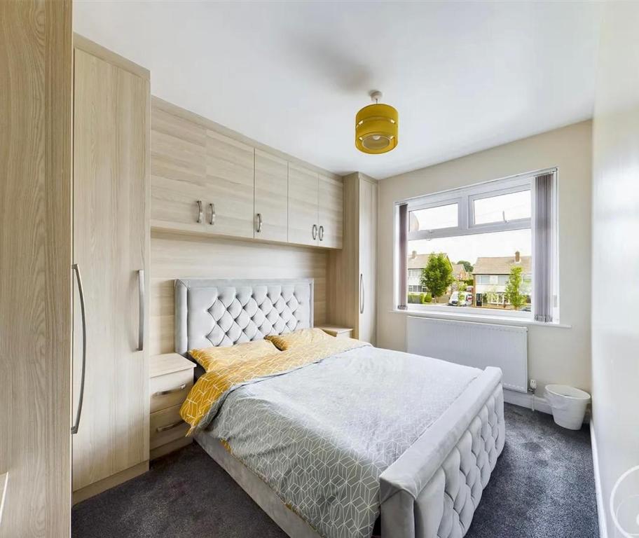 Un dormitorio con una cama grande y una ventana en Mordern home, en Kippax