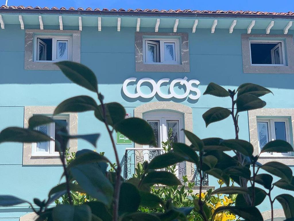 a cocos sign on the side of a building at COCOS SURFHOUSE in San Juan de la Arena
