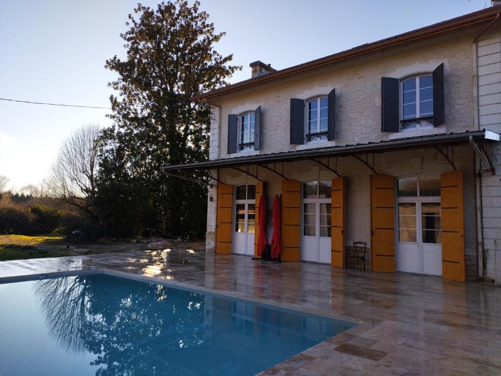 a house with a swimming pool in front of it at A la Gare in Saint-Nexans