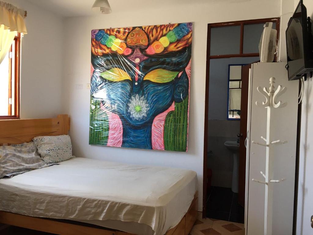 ein Schlafzimmer mit einem Wandgemälde in der Unterkunft Hospedaje Los Lobos in Cerro Azul