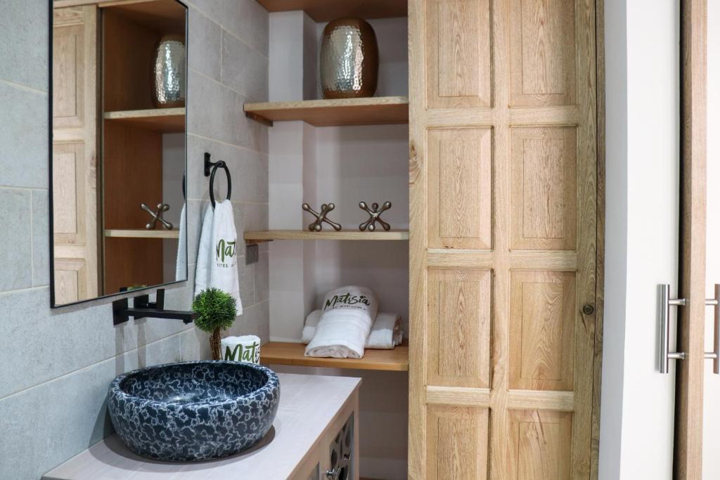 a bathroom with a sink and a wooden door at Matisia Hotel Boutique in Guaduas