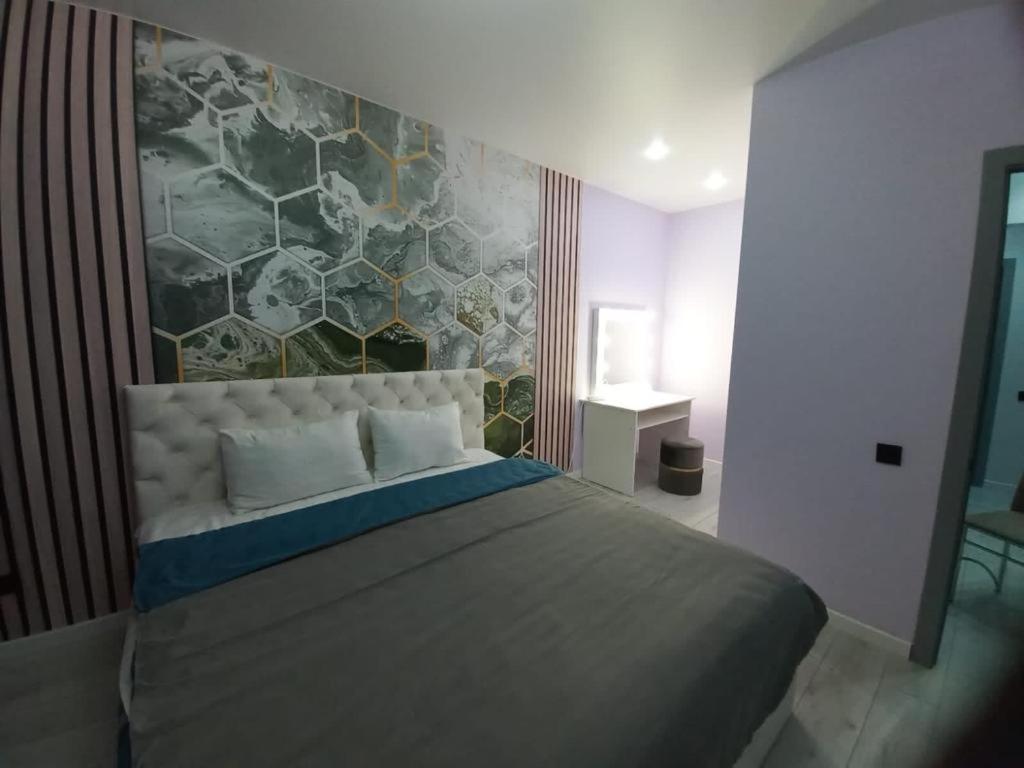 a bedroom with a large bed with a stone wall at Sezim Qala 10 in Taldykolʼ