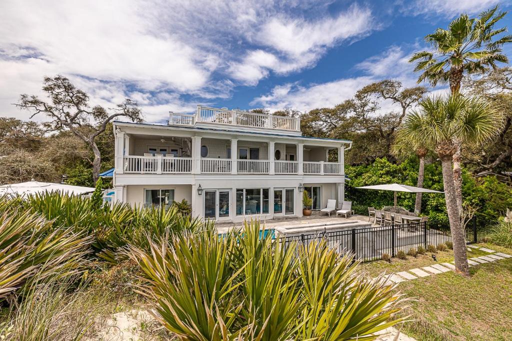 uma casa branca com um alpendre e uma palmeira em JEKYLL HOUSE home em Jekyll Island