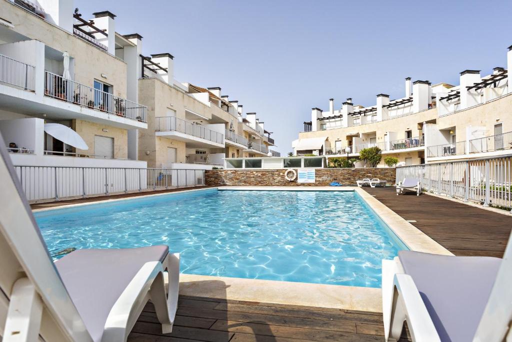 a swimming pool in the middle of two apartment buildings at Camélia Apartment in Santa Luzia